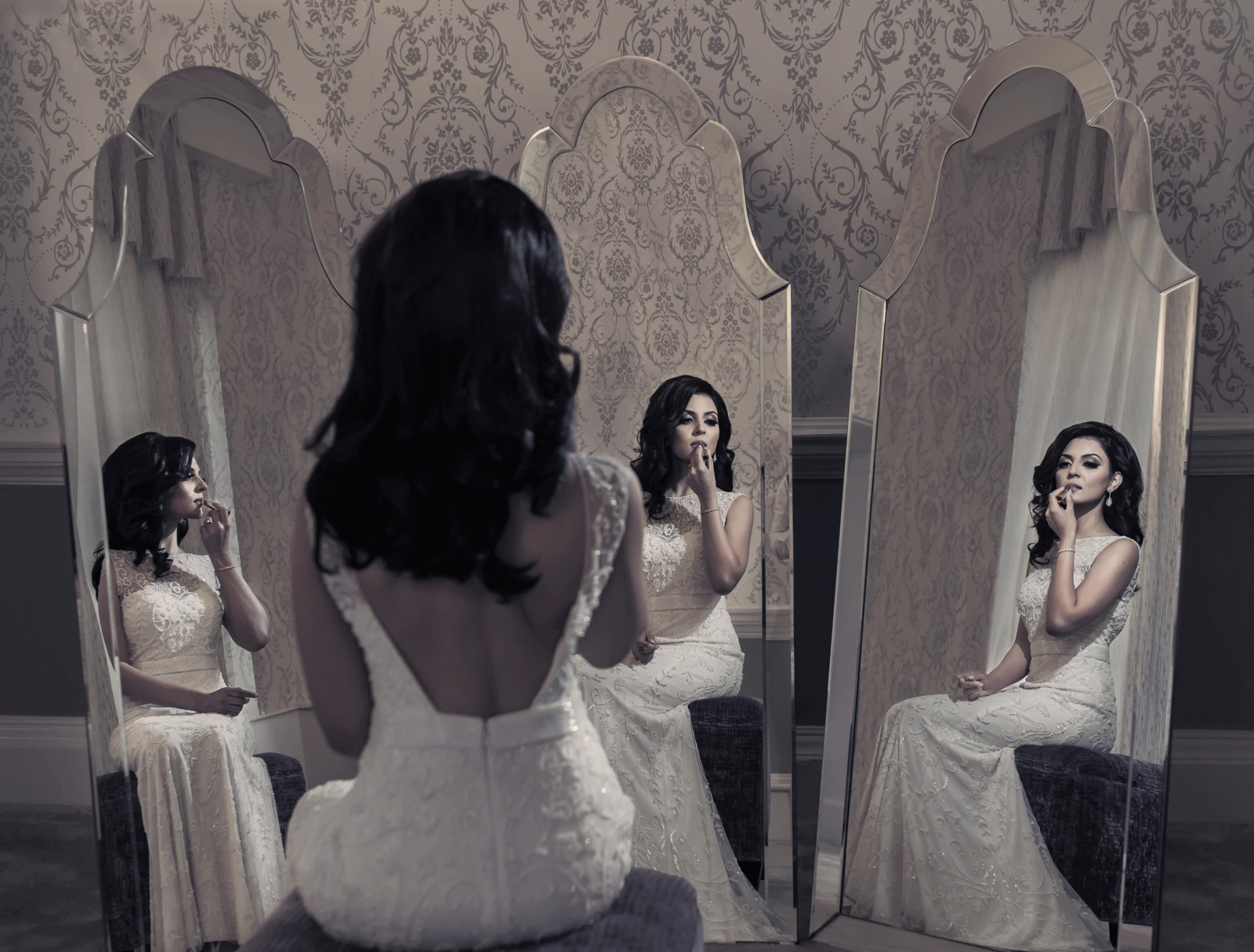 bride in white dress getting ready with three mirror reflections