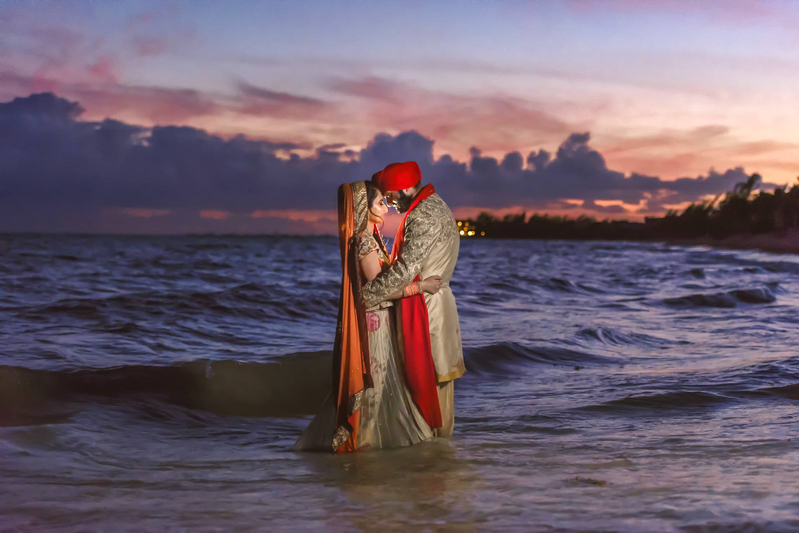 wedding couple in love in the sea over the sunset in cancun